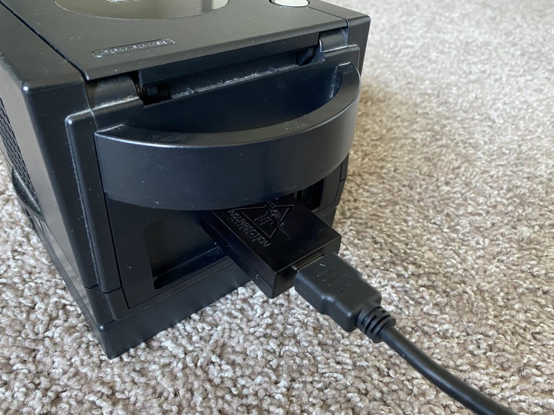 A picture of the rear of the GameCube, with Carby and HDMI cable attached
