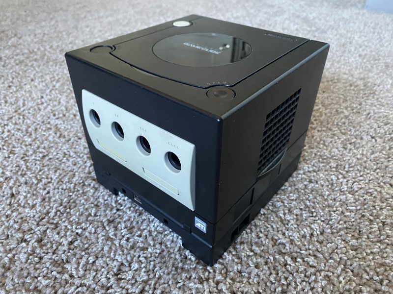 A picture of a black GameCube sitting on carpet